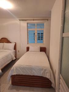 a bedroom with a bed and a window at Casa muy cerca de plaza central in San Cristóbal de Las Casas