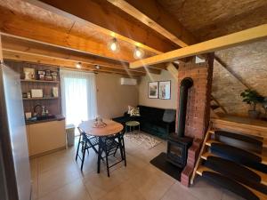 a kitchen and living room with a table and a fireplace at Domek LuźnAgro Góry Sowie in Łomnica