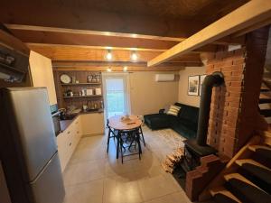 a kitchen and a living room with a table and a refrigerator at Domek LuźnAgro Góry Sowie in Łomnica +11 photos