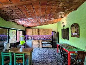 a kitchen with a table and a refrigerator at Casa Rosa in Sayulita