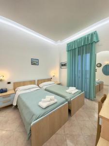 a bedroom with two beds with towels on them at Hotel Le Tre Caravelle in Palinuro