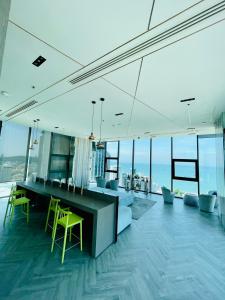 a living room with a table and yellow chairs at The base Central luxury by Numam in Pattaya