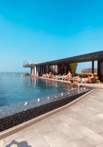 a swimming pool with people laying in the water at The base Central luxury by Numam in Pattaya