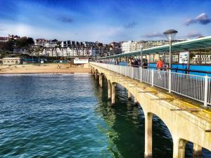 un ponte sull'acqua con una spiaggia e edifici di The Ravensbourne Hotel a Bournemouth