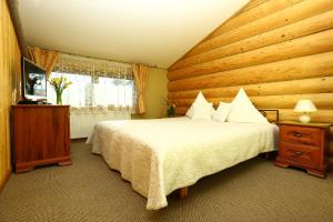 a bedroom with a bed and a wooden wall at Arciau Juros in Palanga