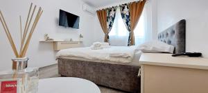 a small bedroom with a bed and a window at Relax Home apartments in Iaşi