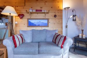 a blue couch in a living room with wooden walls at The Stag's Chalet by Gryon Luxury in Gryon