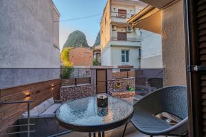 a balcony with a glass table and chairs at Villa KONTOULIS in Kalabaka