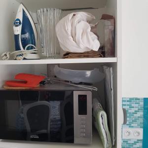 a cupboard with a microwave in a room at L'ampli sur jardin in Noirmoutier-en-l'lle +17 photos