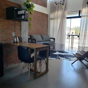 a living room with a table and chairs and a couch at loft charmoso com lareira, a beira mar in Balneário Gaivotas +45 photos