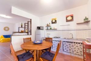 een keuken en eetkamer met een tafel en stoelen bij Stagnone Holiday Apartment in Birgi Vecchi