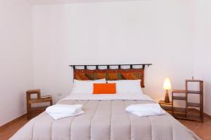 ビルジ・ヴェッキにあるStagnone Holiday Apartmentのベッドルーム1室(大型ベッド1台、オレンジ色の枕付)