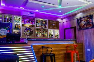 MeranにあるDel Migos Hotel & Suitesのスツール2つとアルコールのボトルを用意したバー