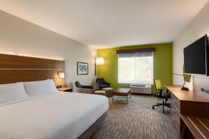 a hotel room with a bed and a flat screen tv at Holiday Inn Express & Suites Hayward - Castro Valley by IHG in Hayward