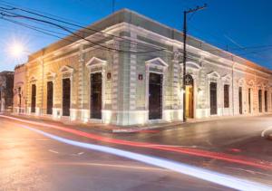 a building on the corner of a street at night at La Casa del Centro, Mérida in Mérida