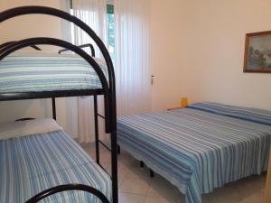 1 Schlafzimmer mit 2 Etagenbetten und einem Stuhl in der Unterkunft Villetta mare blu Baia Verde in Gallipoli