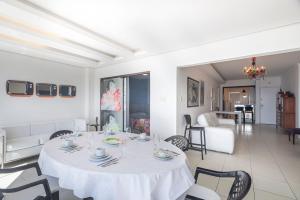 a white dining room with a table and chairs at ITNC191 - Vista mar incrível do alto do 19º andar in Balneário Camboriú