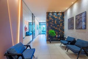 a waiting room with blue chairs in a building at ITNC191 - Vista mar incrível do alto do 19º andar in Balneário Camboriú
