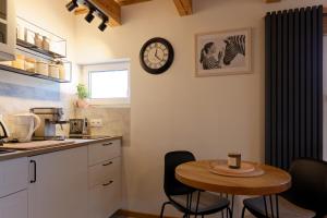 a kitchen with a table and a clock on the wall at Studio w zabytkowej kamienicy in Gdynia