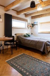 a bedroom with a bed and a table with a rug at Studio w zabytkowej kamienicy in Gdynia