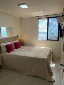 a bedroom with a large bed with red pillows at Apt Orly 903 I 1min da Praia I Piscina I Vista Mar in Maceió