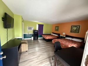 a hotel room with two beds and a flat screen tv at Royal Inn Motel in Waynesboro +8 photos