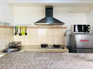 a kitchen with a stove and a refrigerator at Dauphin Gourmand in Flic-en-Flac