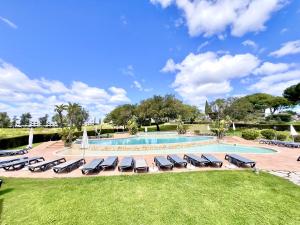 a pool with chaise lounge chairs and a resort at Albufeira Balaia Golf Vilage 7 With Pool by Homing in Albufeira