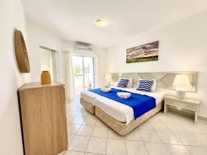 a bedroom with a large bed with blue sheets at Albufeira Balaia Golf Vilage 7 With Pool by Homing in Albufeira