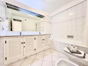 a bathroom with a sink and a tub and a toilet at Albufeira Balaia Golf Vilage 7 With Pool by Homing in Albufeira +29 photos
