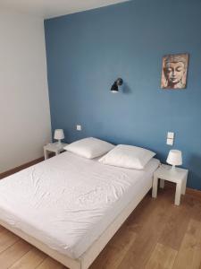 a bedroom with a bed with a blue wall at A l'horizon du Mont in Pontorson