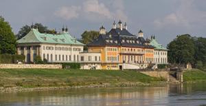 a large building on a hill next to a river at Ferienhaus-der-Villa-Elsa in Dresden