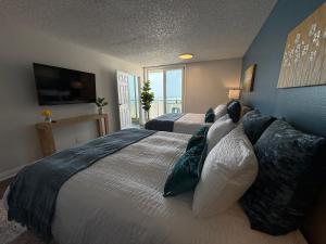 a bedroom with two beds and a large window at Oceanfront Sanctuary 1 BR Beach Access 218 in Hermosa Beach +40 photos