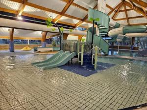 a swimming pool with a water slide in a building at Lake Escape - Hoburne Cotswolds in South Cerney