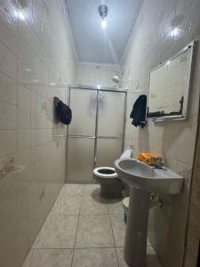 ein Badezimmer mit Dusche, Waschbecken und Toilette in der Unterkunft Casa na Praia 013 in Itanhaém