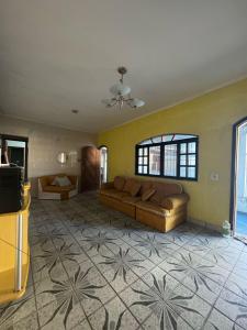 ein großes Wohnzimmer mit Sofa und TV in der Unterkunft Casa na Praia 013 in Itanhaém