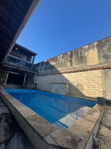 einen Pool vor einer Backsteinmauer in der Unterkunft Casa na Praia 013 in Itanhaém