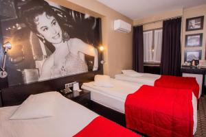 a hotel room with two beds and a poster of a woman at Maltepe 2000 Hotel in Ankara +37 photos