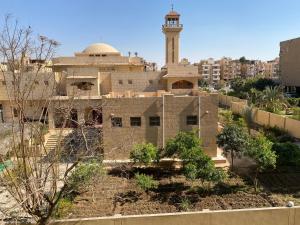 un edificio con una mezquita con una torre de reloj en مكانك - MakanK, en Seis de Octubre