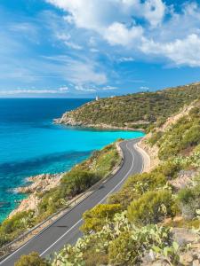 an empty road on a hill next to the ocean at DomoMea - Le Gioie di Laura in Su Forti