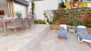 a patio with chairs and a table and a fence at Maison, piscine, plage, commerce restaurant in Roses
