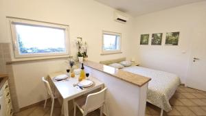 a room with a bed and a kitchen with a table at Appartamento da Vjeri in Pula