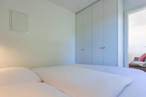 a white bed in a room with a window at Ferienhaus Rügenblick in Stahlbrode
