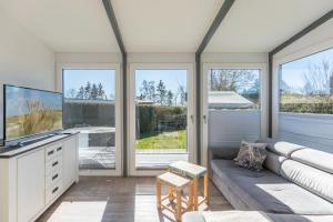 a living room with a couch and some windows at Ferienhaus vor Rügen in Sundhagen
