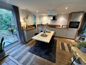 a kitchen with a wooden table in a room at Natures Edge Cabin in Suckley