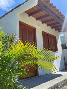 a white house with wooden doors and a plant at Finca la playita in Jordán