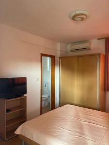 a bedroom with a bed and a flat screen tv at Lavanda Apartments in Pakoštane