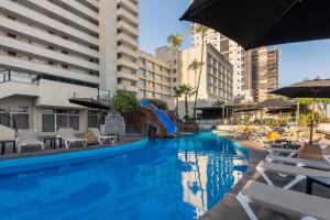 a swimming pool with a slide in a hotel at Don Pelayo Pacific Beach in Mazatlán