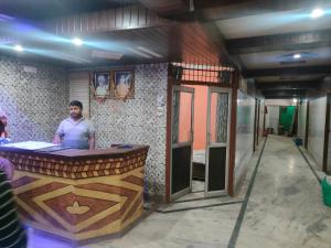Un uomo in piedi in un bar in una stanza di Hotel Subhadra Guest House a Mathura