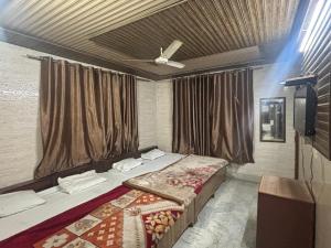 una camera da letto con un letto e un ventilatore a soffitto di Hotel Subhadra Guest House a Mathura